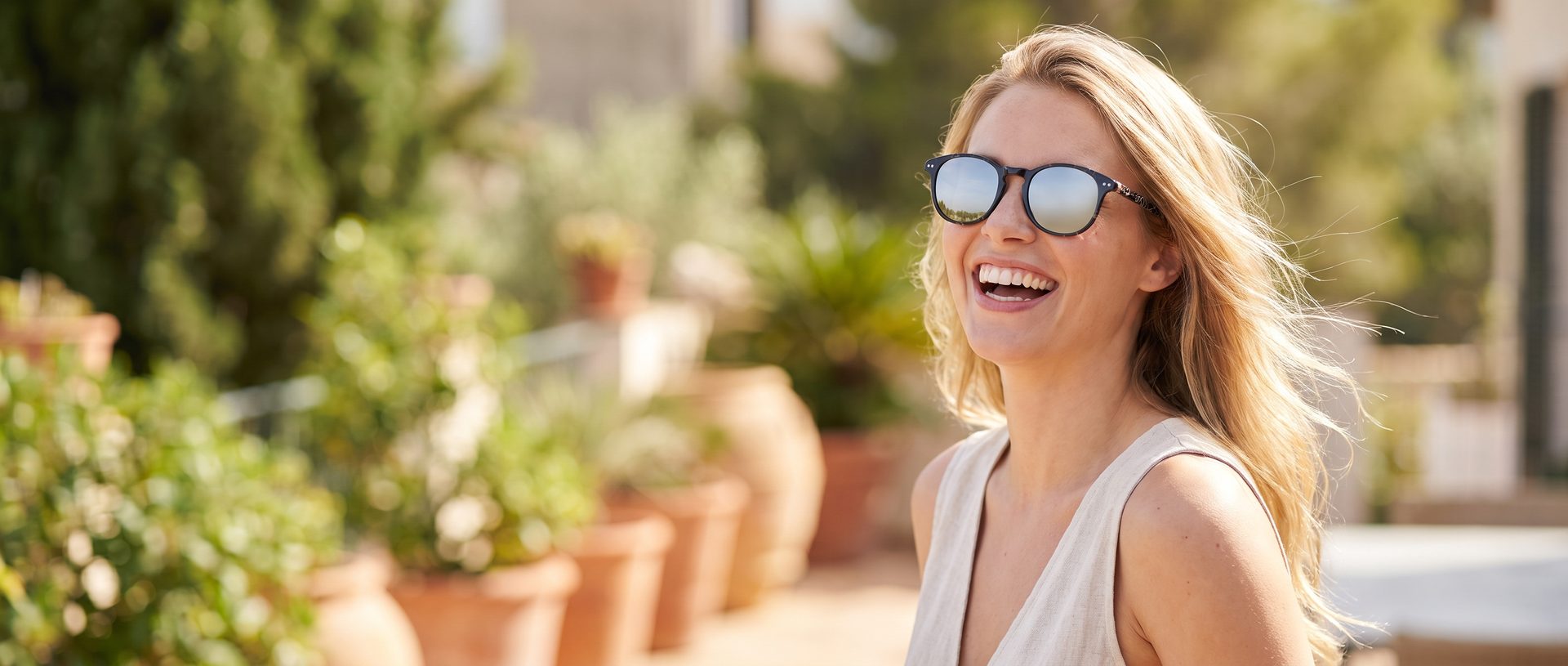 Woman on a summer terrace wearing Boom sunglasses